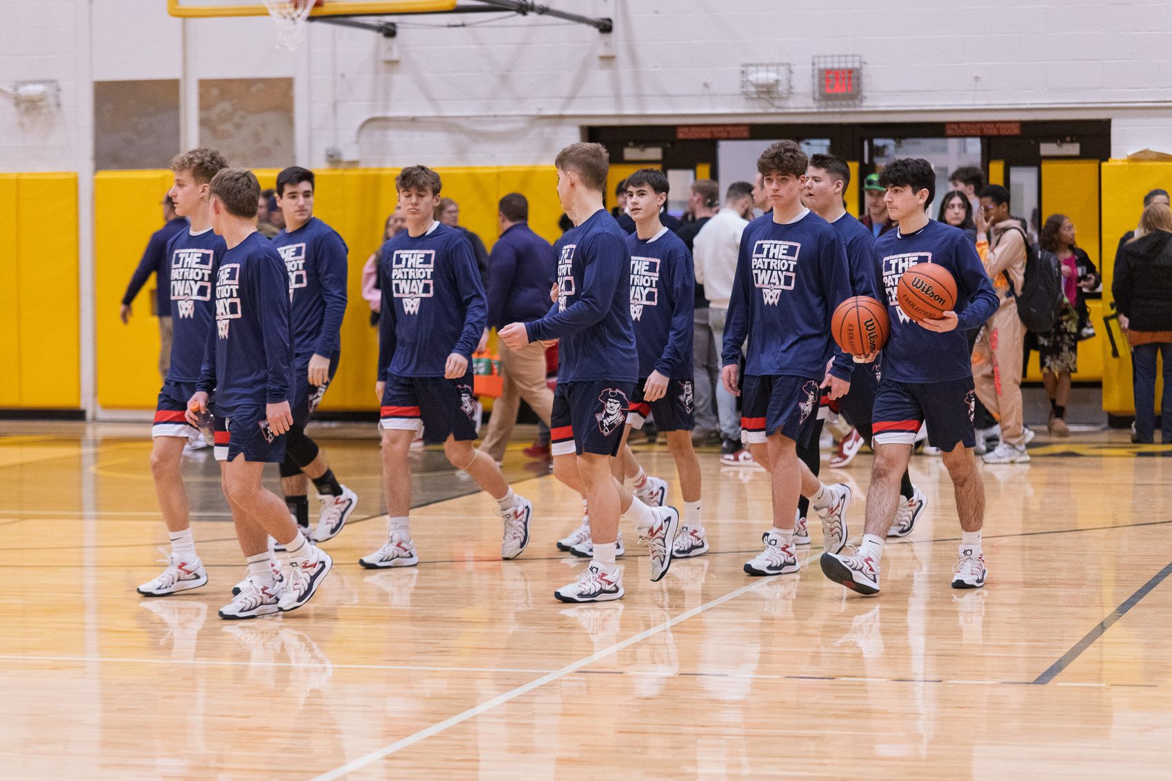 The Patriots basketball team taking the floor