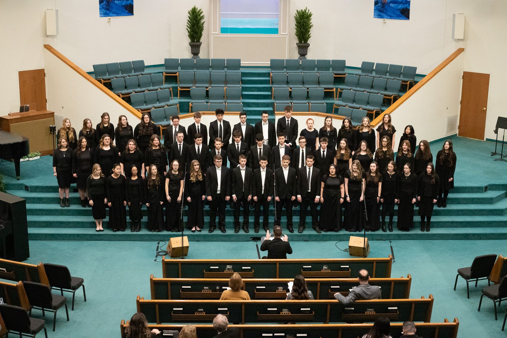 A large student choir performing on stage